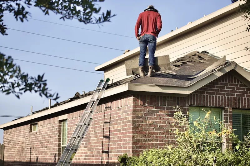 Professional roofer working on a residential roof in Rendon